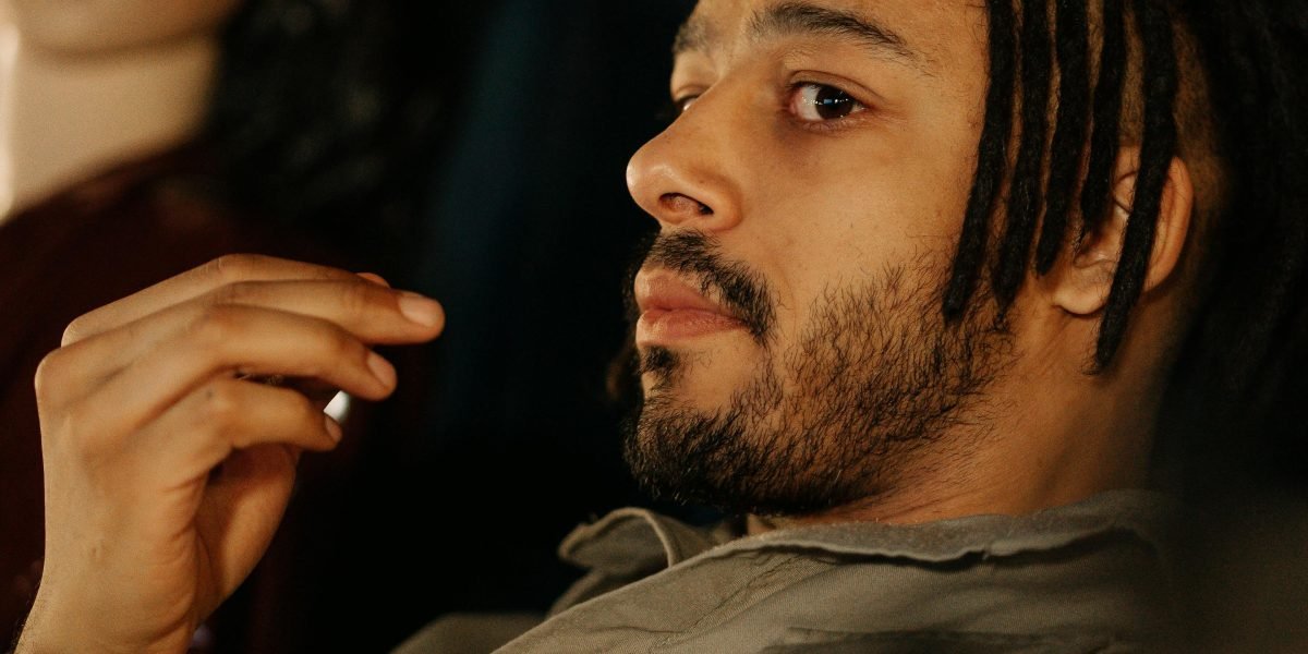 A person reflecting on past memories while watching a film, evoking a sense of nostalgia.