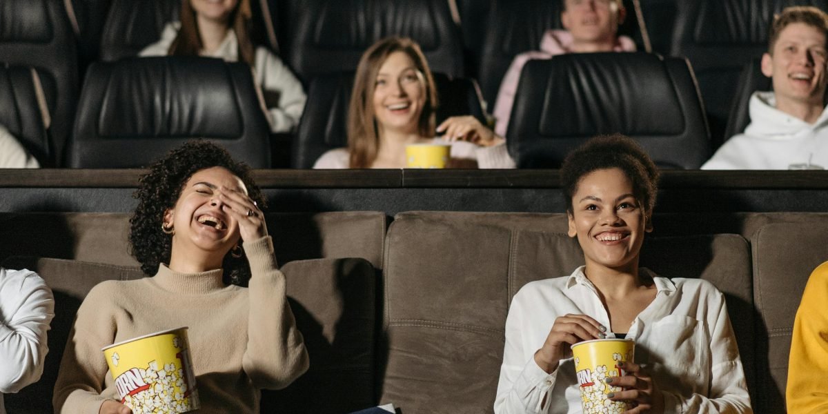 A diverse audience laughing and enjoying a lively stand-up comedy performance in a dimly lit club.