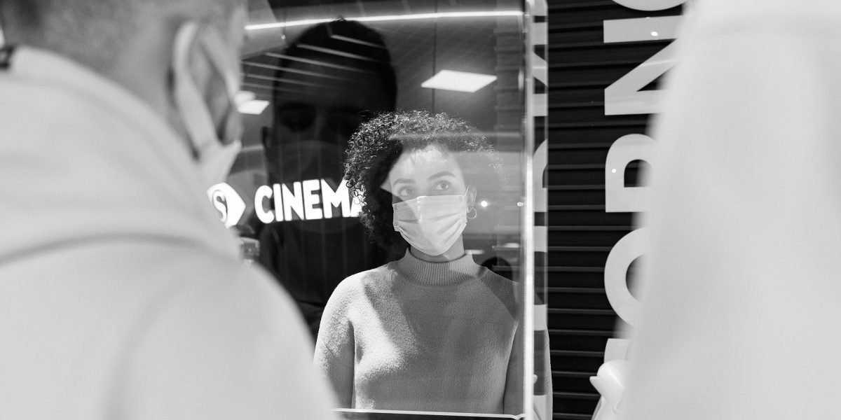 A person thoughtfully browsing through a film collection, representing the discovery of hidden gems in an actor's filmography.